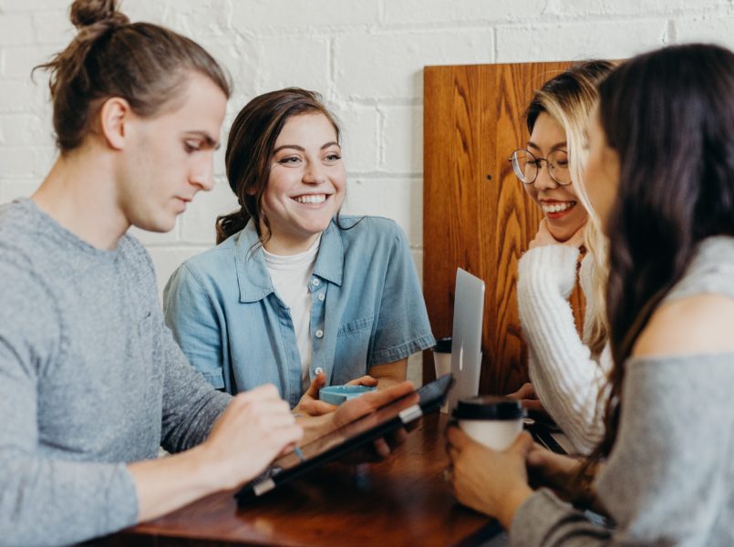 Group of young professionals meeting with tablets and coffee